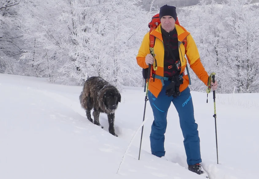 Ski tourer with dog in fresh snow Accursed Mountains winter 2026