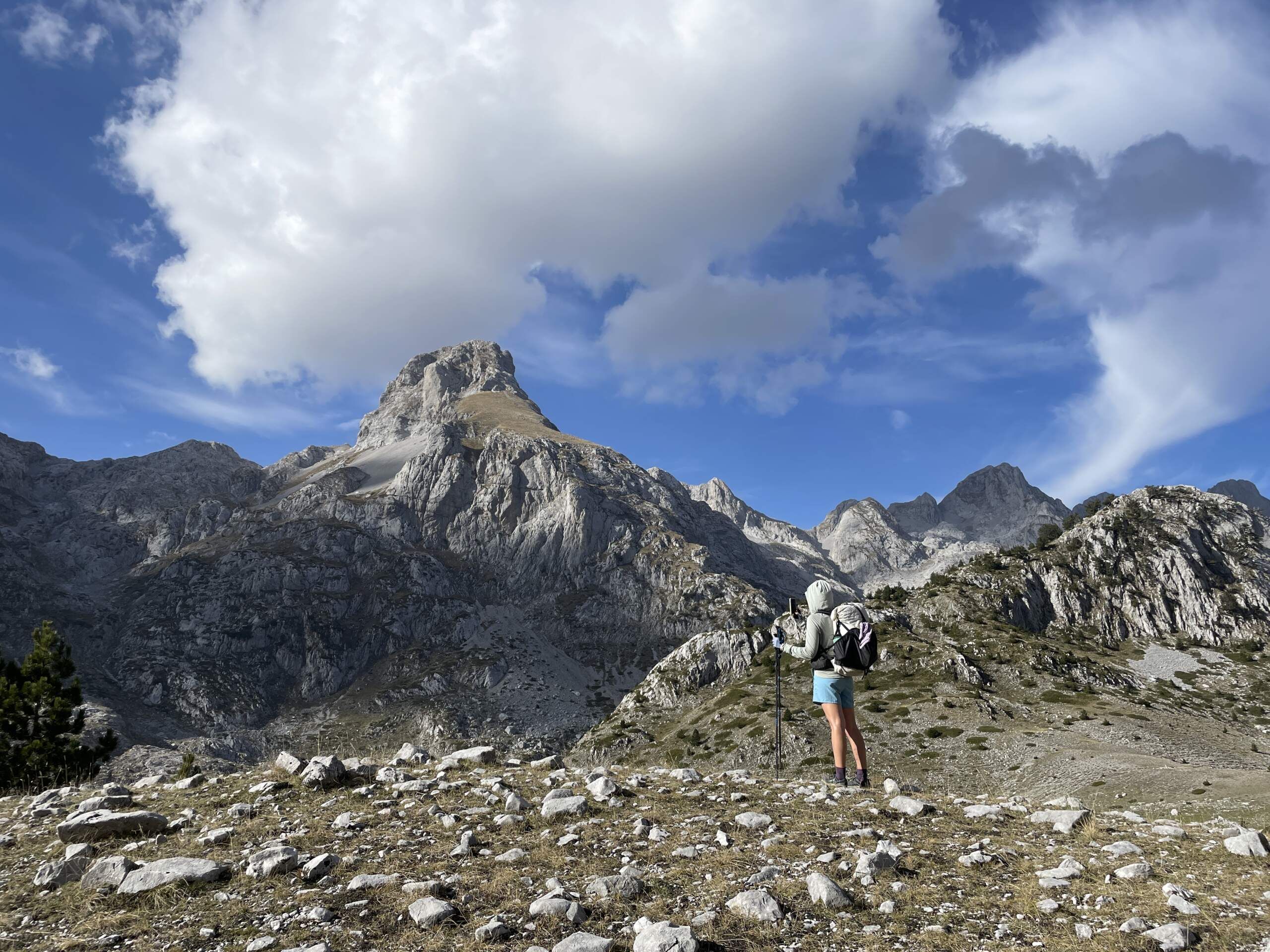 Solo hiker photographing a peak in the Albanian mountains