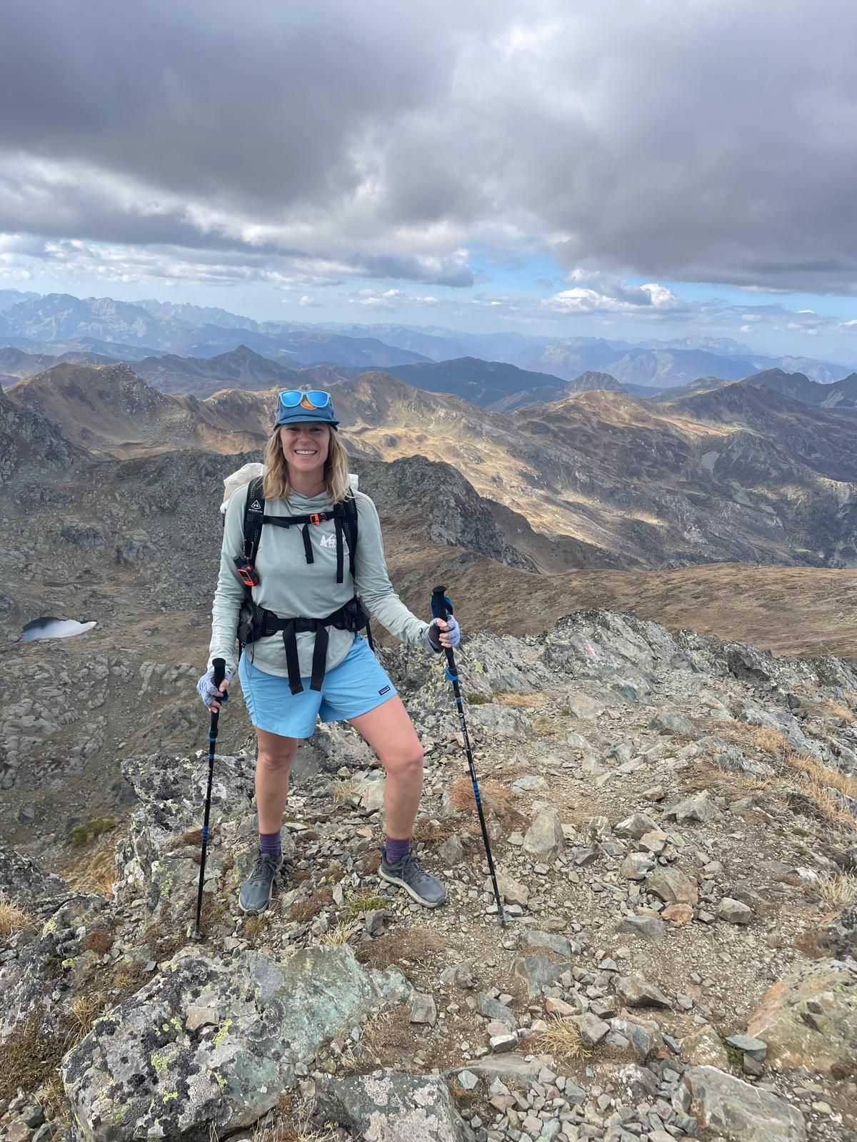Solo female hiker on a mountain summit during the self-guided Peaks of the Balkans